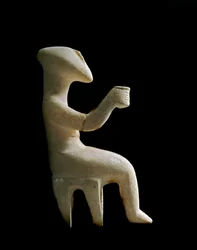Kunst der Kykladen: „Auf einem Hocker sitzende Figur“. Marmoridol mit Ockereinlagen. Kykladische Zivilisation (-3200 bis -2000). Höhe 15.2 cm. Athen, Archäologisches Nationalmuseum (Inv. 3910)