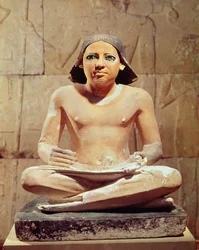Im Schneidersitz sitzender Schreiber mit einer Papyrusrolle, aus Sakkara, Altes Reich, ca. 2475 v. Chr.