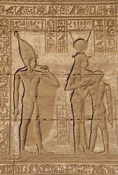 Ägyptische Antike: Römischer Mammisi, der die Geburt von Ihy, Sohn der Hathor, feiert - Detail von Reliefs und Hieroglyphen: die Göttin Isis - Hathor stillt ihren Sohn Ihi und hinter ihr ein weiteres Bild von Ihi mit einem Finger im Mund, das anzeigt, dass