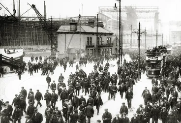 Feierabend in der Harland und Wolff Werft, Belfast, Irland mit der Titanic im Hintergrund im Bau, 1910-11