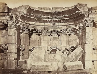 Detail der sogenannten "Räume" in der archäologischen Zone von Heliopolis oder Baalbek, antike syrische Stadt, jetzt Libanon. Ein Mann posiert, sitzend auf den Ruinen