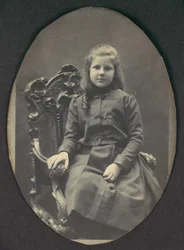 [Mädchen mit Locken, sitzend, Dreiviertellänge], 1890er Jahre