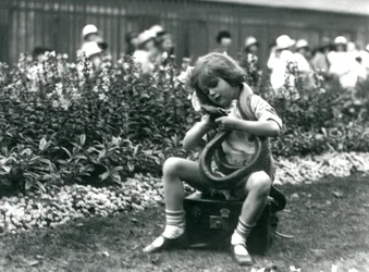 Ein junges Mädchen Betty hält eine östliche Indigo-Schlange, während sie auf einem Lederkoffer sitzt, London Zoo, 1924