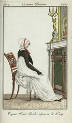 Modische Frau sitzt vor einem Kamin
