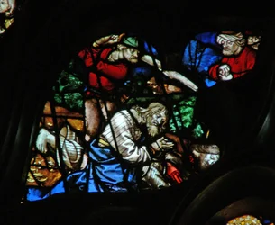 Das westliche Rosenfenster zeigt eine Szene aus dem Buch der Offenbarung: zwei Zeugen werden getötet, mit einer turbantragenden Figur, die zusieht (11:3-11).