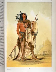 Indianischer Blackfoot-Schamane mit Tamburin und Speer