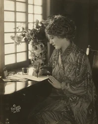 Mary Pickford, im Kimono, schreibt an einem Schreibtisch, ca. 1918 (s/w Foto)