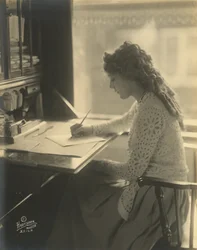 Mary Pickford schreibt an einem Schreibtisch