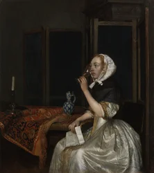 Junge Frau mit einem Glas Wein, einen Brief in der Hand haltend