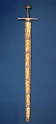 Kaiserschwert der Heiligen Römischen Kaiser mit teilweise vergoldetem Knauf und Querbalken, der Griff mit Silberdraht umwickelt und die Scheide besteht aus vierzehn Goldfolienplatten, die mit souveränen Figuren verziert sind