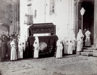 Begräbnisprozession der Kongregation von San Francesco in Neapel. Im Vordergrund, vor einer Kirche, begleiten zahlreiche 