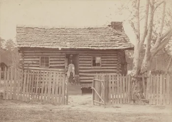 Albuminabzug einer Frau und zwei Kinder vor einem Blockhaus in Georgia, 1880er Jahre