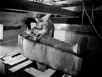 Entdeckung des Grabes von Pharao Tutanchamun im Tal der Könige (Ägypten): Im Grabkammer, Howard Carter arbeitet am Deckel des zweiten Sarges, Oktober 1925, Foto von Harry Burton
