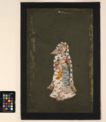 Eine stehende Frau in einem weißen Sari mit Blumenmuster und einem Umhang mit Pfauenfedermuster