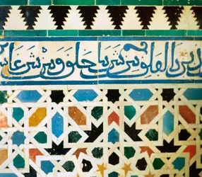 Ring mit Inschrift in blauen Kacheln auf weißem Hintergrund, der Sätze aus dem Koran wiedergibt