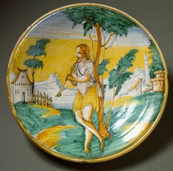 Flötenspieler in einer Landschaft. Keramikplatte, hergestellt in Viterbo, Italien. Ende des 16. Jahrhunderts. Florenz, Museo Nazionale del Bargello