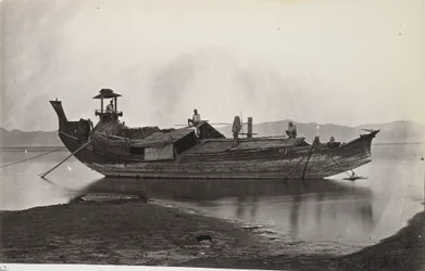 Ein Balkenblick auf ein laung-zat oder Paddy-Boot, das am Ufer des Irrawaddy-Flusses festgemacht ist