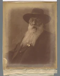 Porträt eines Mannes mit Bart und Hut und einer Zigarre im Mund