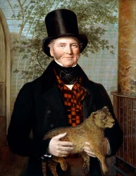 Halbfiguriges Porträt von Edward Cross in schwarzem Mantel und rot kariertem Gilet, ein Löwenjunges haltend