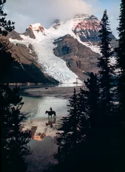 Einsames Pferd, Reiter reflektieren auf See am Fuße des höchsten Gipfels Kanadas. Mount Robson...