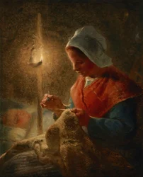Frau näht bei Lampenlicht