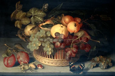 Korb mit Früchten und Admiral-Schmetterling auf Steintisch