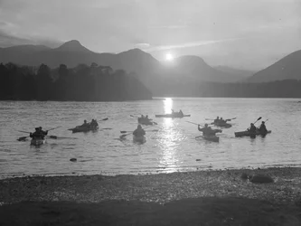 Eine Ansicht von Menschen, die auf Derwentwater Kanu fahren, entweder bei Sonnenaufgang oder Sonnenuntergang