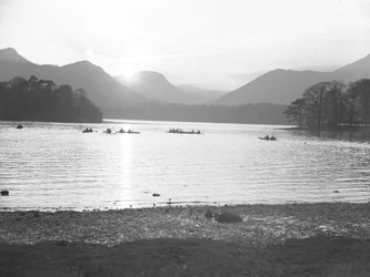 Eine Ansicht von Menschen, die auf Derwentwater Kanu fahren, entweder bei Sonnenaufgang oder Sonnenuntergang