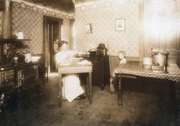Frau, die Borsten in Zahnbürsten in ihrer Küche einsetzt, ca. 1912