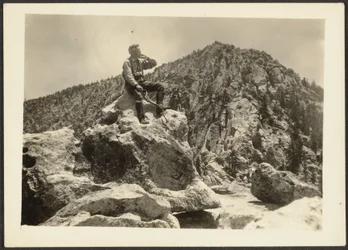 [Mann auf Felsen sitzend]