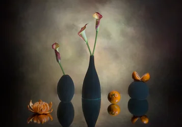 Stimmungsvolle Calla-Lilien und Orangen