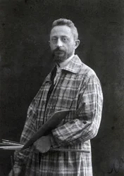 Dreiviertelporträt des Malers Guido Spadolini. Er trägt einen langen Kittel und hält Pinsel und Palette in der linken Hand, 26.11.1901