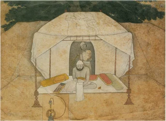 Balwant Singh sitzt schreibend auf einem Feldbett