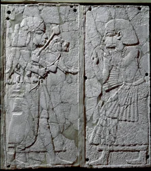 Phönizische Zivilisation: Bettverzierung mit einem Elfenbein-Flachrelief, das einen Wächter darstellt, der dem König einen Löwen vorführt. Von der Stätte Ugarit, einer antiken syrischen Stadt auf dem Tell Ras Schamra. 14. Jahrhundert v. Chr. Maße 24 cm.