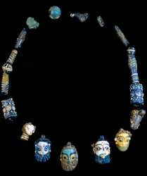 Halskette aus Glaspaste mit Anhängern in Form bärtiger Köpfe, ursprünglich aus Olbia, heute im Archäologischen Nationalmuseum von Cagliari aufbewahrt