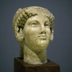 Mädchenkopf (Kore), Skulptur der römisch-hellenistischen Periode (3. 2. Jahrhundert nach unserer Zeitrechnung), sehr ausdrucksstarkes Gesicht, hervorstehende Wangenknochen nach Osten, Lächeln, lockiges Haar, archaischer Stil von Ionien im 6. Jahrhundert vo