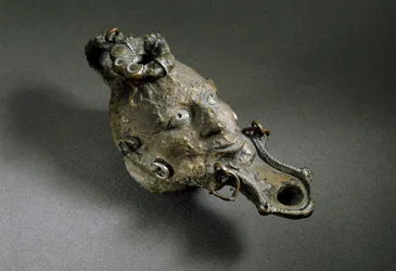 Römische Kunst: Bronzeölleuchte in Form eines Gesichts