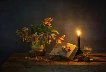 Buch und Blumen im Kerzenlicht