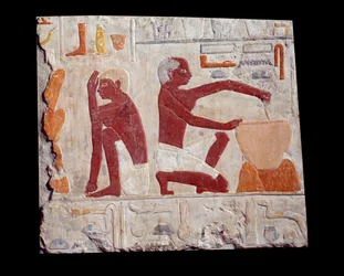 Altägyptische Kunst: Brotbacken. Ein Mann bereitet Kuchenteig zu, ein anderer überwacht das Backen in Brotformen. Kalkstein (2500-2350 v. Chr.), 5. Dynastie. Paris, Musée du Louvre