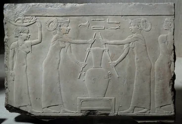 Ägyptische Antiquität: niedriges Kalksteinrelief, das Frauen darstellt, die Lilienblüten pressen, um die Essenz namens „Lirinon-Extraktion“ zu gewinnen, um 500-400 v. Chr. (Saite-Ära?). Niedrige Epoche. Sonne 0,29x0,37 m Paris, Musee du Louvre
