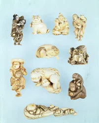 Auswahl an Netsuke: Ikkuha Sennin trägt die Kurtisane von Benares; sitzender Welpe; Abe no Yasuneri hält ein Baby; Gamma Sennin; liegendes Pferd; Krieger bezwingt einen durchgegangenen Ochsen; stehender Holländer hält einen langschwänzigen jungen Hahn
