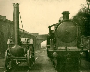 Ein Modell von Stephensons Rocket neben einer Lokomotive der George the Fifth Klasse, London