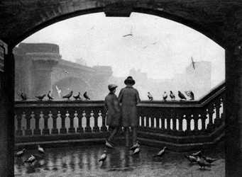 Ein Mann und ein Junge füttern die Vögel an der Blackfriars Bridge, London