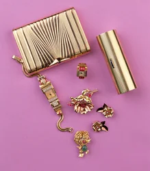 Auswahl an Art-Deco-Schmuck: zwei Zigarettenetuis; Rubin-Cluster-Blumenbrosche und Ohrringe; Cocktailuhr (Gold)