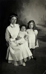 Eine „Krankenschwester“ posiert in den 1920er Jahren mit Kindern.