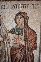Atropos - Eine der drei Schicksalsgöttinnen, dargestellt mit einer offenen Schriftrolle, auf der das Leben des Achilles geschrieben steht - Detail des Panels, das das erste Bad des Achilles darstellt - Paphos-Mosaiken, Villa des Theseus, 5. Jahrhundert n. 