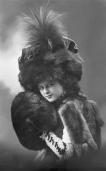 Mode: eine junge Frau im Pelzmantel, Federhut und Ärmel (1920-1930er Jahre, historisches Modefoto)