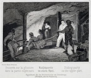 Salzmine: Besucher setzen sich in den oberen Teil der Rutsche, die in die unterirdischen Gänge der Mine führt, in Durrnberg, Österreich