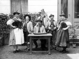 Porträt einer Gruppe von Männern in traditionellen bayerischen Trachten, einige als Frauen verkleidet (Transvestiten) um 1910. Deutschland. Historische Fotografie, Männer, einige als Frauen verkleidet, um 1910, Bayern, Deutschland.