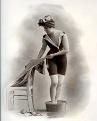 Junge Frau im Badeanzug (aus der Belle Époque) nimmt ein Fußbad, um 1900 (s/w Foto)